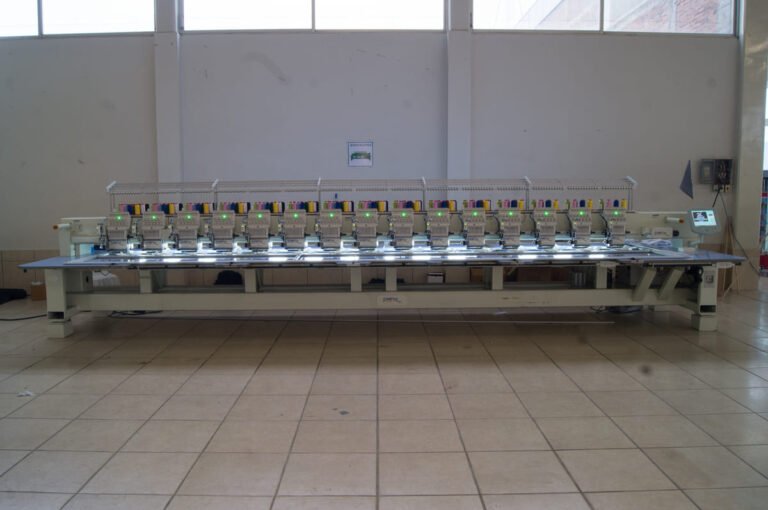 Bordadora plana CAMFive realizando bordado sobre tela, ideal para producción textil profesional y personalizada.