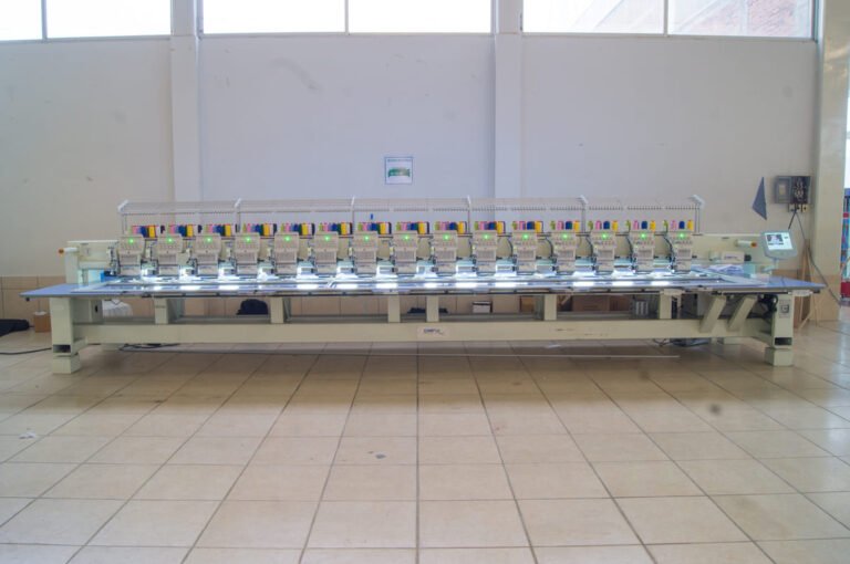 Bordadora plana CAMFive realizando bordado sobre tela, ideal para producción textil profesional y personalizada.