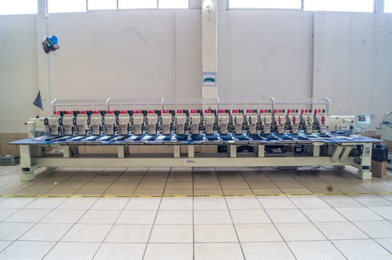 Bordadora plana CAMFive con pantalla táctil visible,y accesorio de lentejuela ideal para bordado industrial de alta precisión.