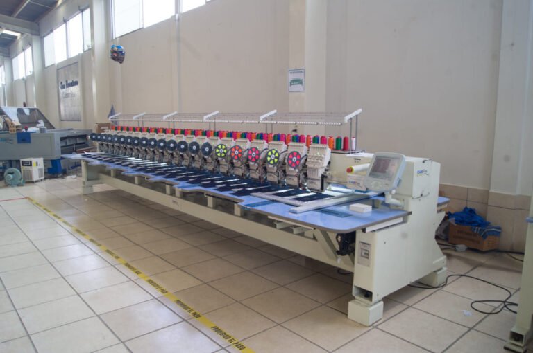 Bordadora plana CAMFive con pantalla táctil visible,y accesorio de lentejuela ideal para bordado industrial de alta precisión.