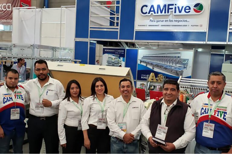 Personal de CAMFive durante evento de exhibición de maquinaria y soluciones tecnológicas, atendiendo al público.