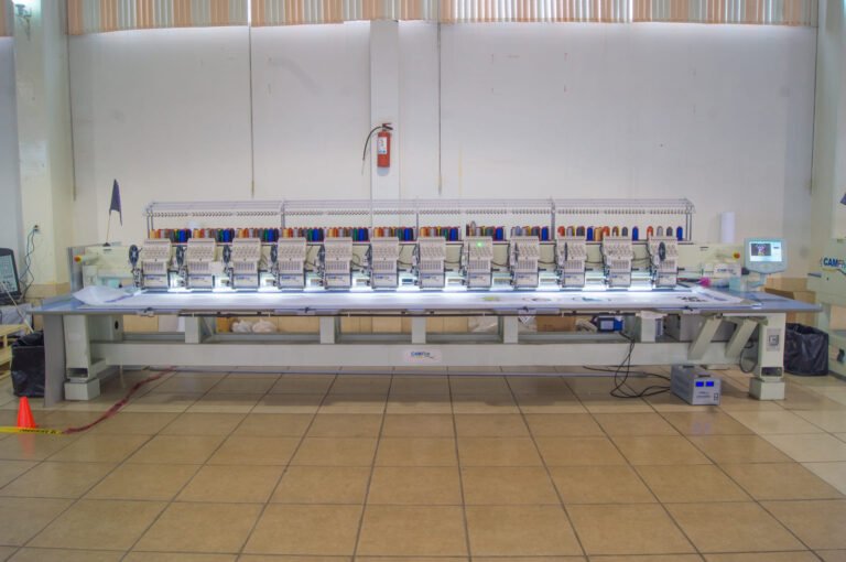 Bordadora plana CAMFive con pantalla táctil visible, ideal para bordado industrial de alta precisión.